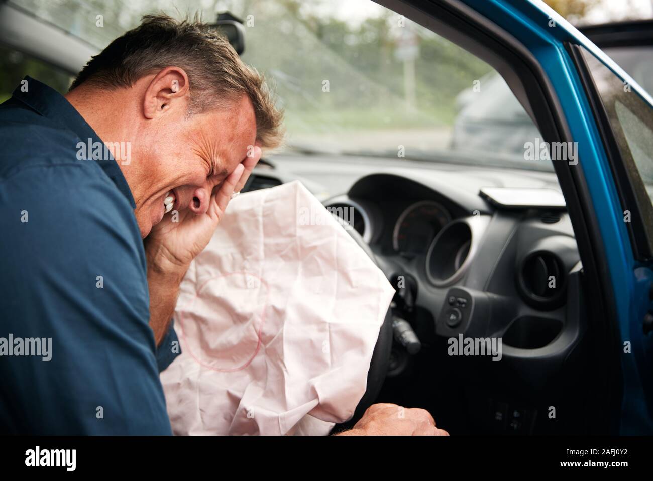 Automobilista maschio ferito in un incidente d'auto con Airbag scattato Foto Stock