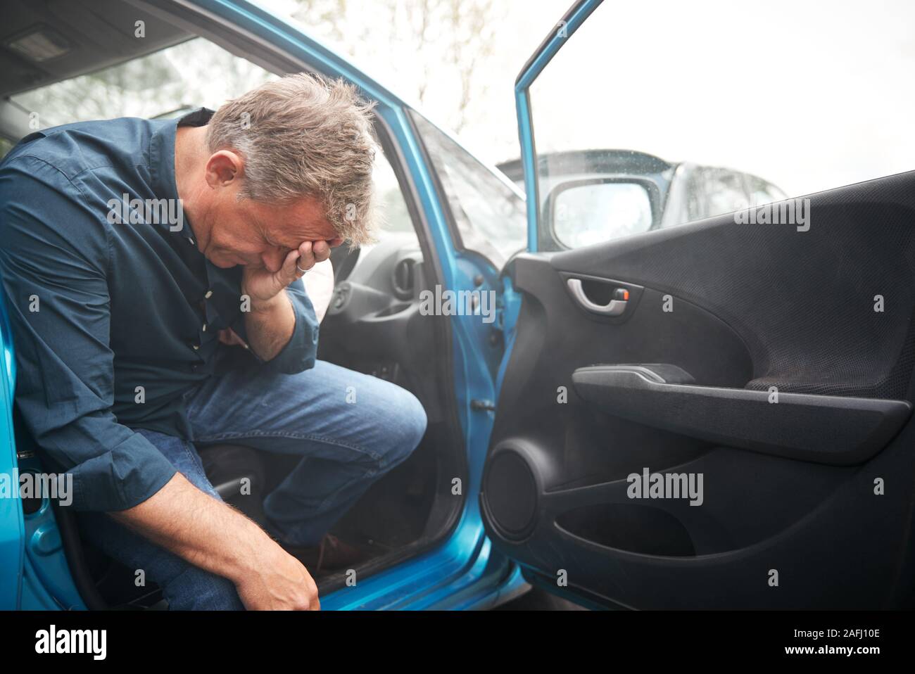 Automobilista maschio ferito in un incidente d'auto con Airbag scattato Foto Stock