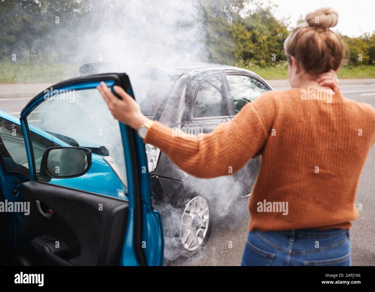 Vista posteriore del automobilista femmina con lesione alla testa di ottenere al di fuori della vettura dopo il crash Foto Stock Vista posteriore del automobilista femmina con lesione alla testa di ottenere al di fuori della vettura dopo il crash Foto Stock