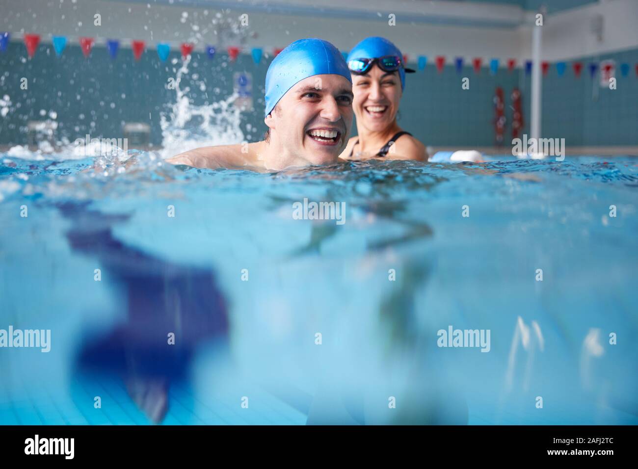 Nuoto femminile Docente dando Uomo Uno per una lezione in piscina Foto Stock