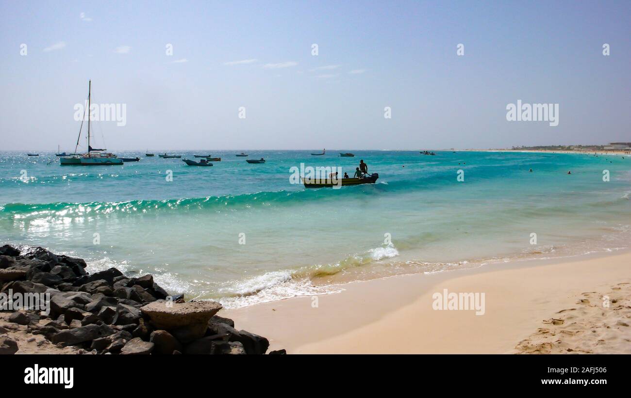 Santa Maria, Sal /Isole di Capo Verde - 19. Novembre, 2015: i pescatori africani il lancio di piccolo skiff di legno da una spiaggia tropicale sulle Isole di Capo Verde Foto Stock
