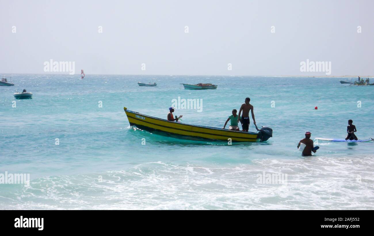 Santa Maria, Sal /Isole di Capo Verde - 19. Novembre, 2015: i pescatori africani il lancio di piccolo skiff di legno da una spiaggia tropicale sulle Isole di Capo Verde Foto Stock