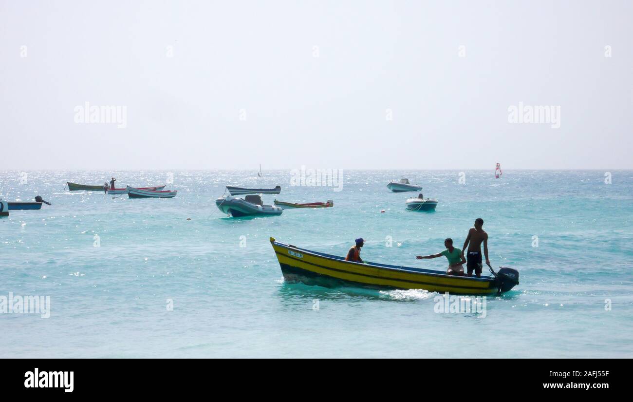 Santa Maria, Sal /Isole di Capo Verde - 19. Novembre, 2015: i pescatori africani il lancio di piccolo skiff di legno da una spiaggia tropicale sulle Isole di Capo Verde Foto Stock