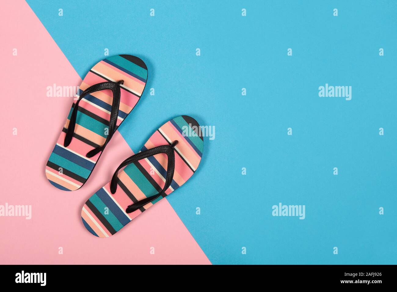 Coppia di colorati flip flop su uno sfondo colorato per una vacanza estiva o il concetto di turismo Foto Stock