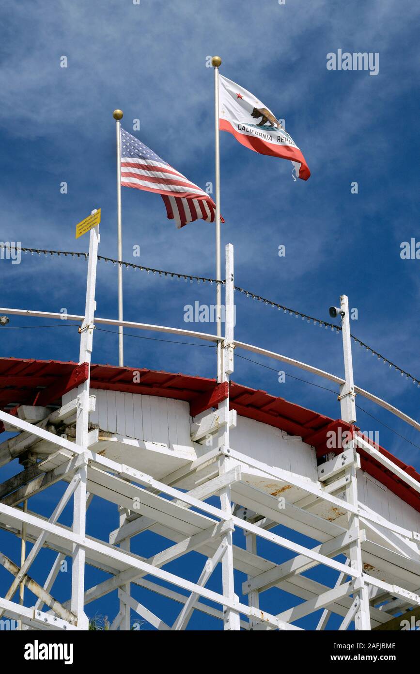 Bandiera americana e californiana sulle montagne russe in legno Big Dipper al Santa Cruz Beach Boardwalk Amusement Park, Santa Cruz, California, USA Foto Stock
