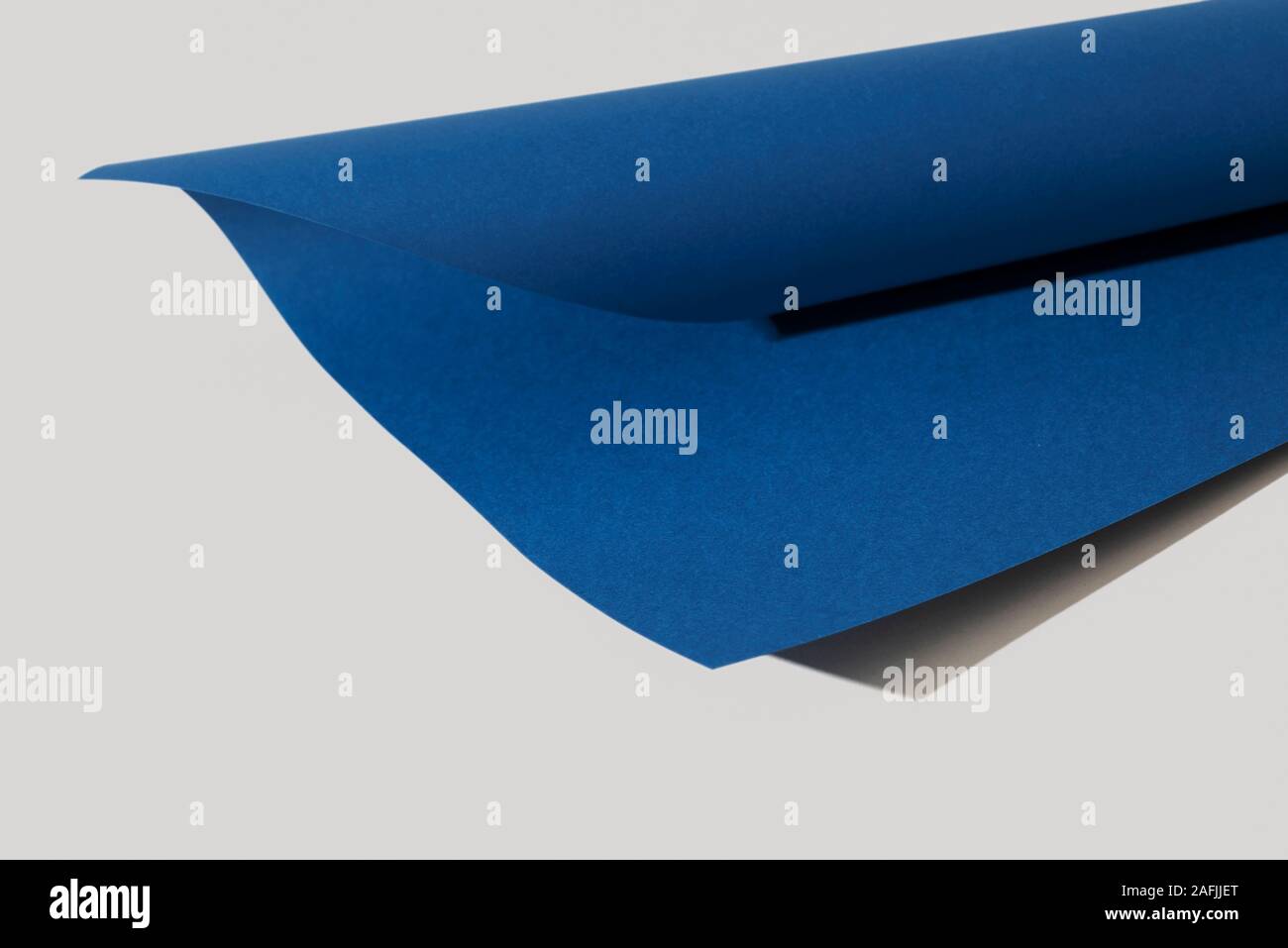 Un cartone nel quartiere alla moda di blu classico, il colore dell'anno 2020, laminate su uno sfondo bianco Foto Stock