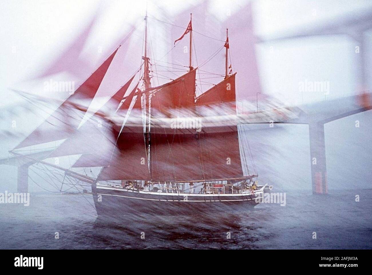Bridge nel Mar Baltico e una tre-masted goletta con red sails vela nelle acque danesi. Foto Stock