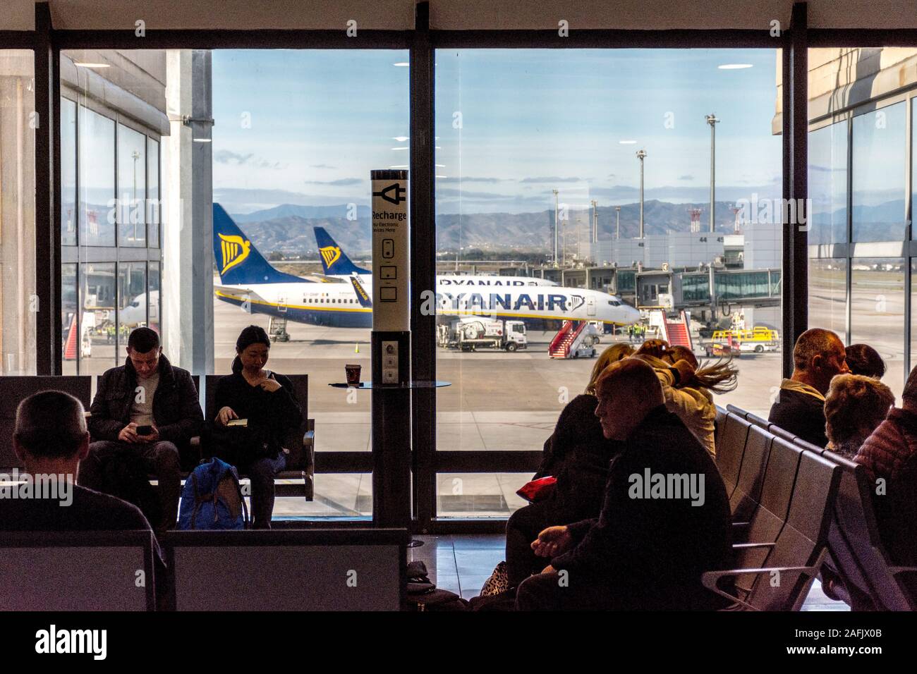 I passeggeri in attesa di un volo in partenza lounge all'Aeroporto di Malaga, Spagna Foto Stock