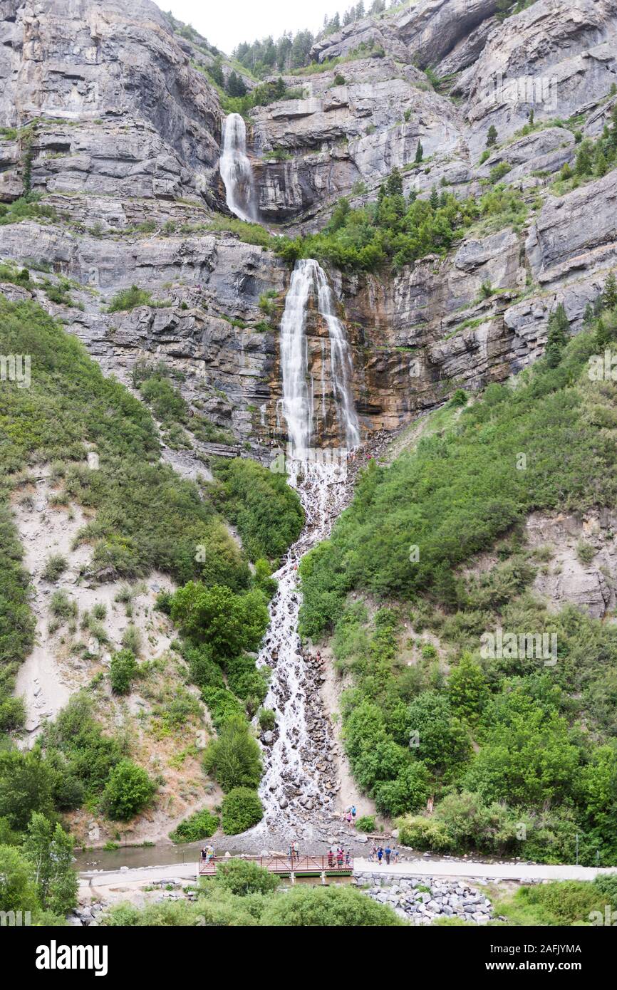 Un multi-tiered cascata di Provo Canyon, Bridal Veil Falls, fluisce giù per il pendio della montagna mentre la gente a guardare e esplorare Foto Stock