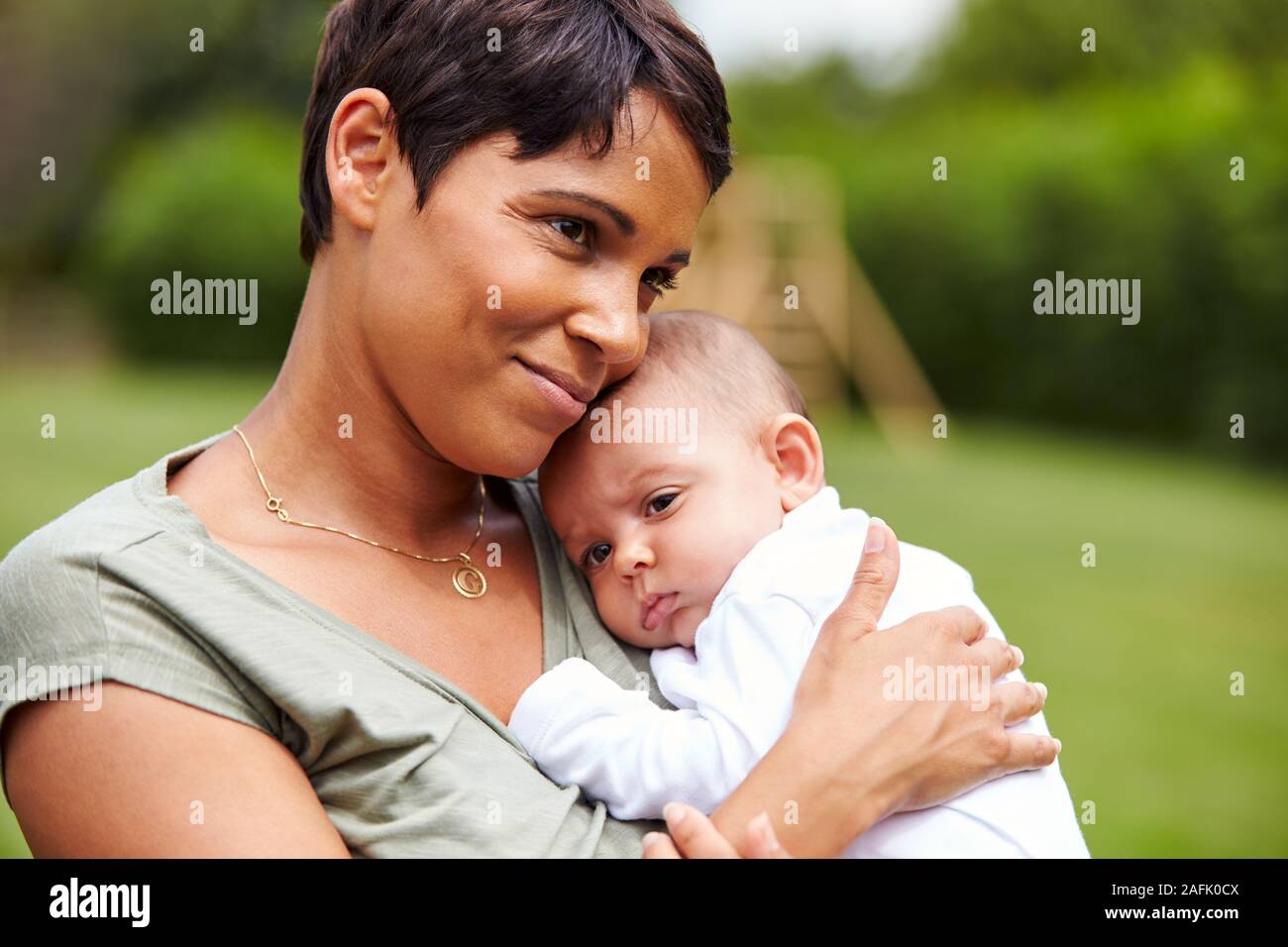 Madre Amorosa azienda 3 Mesi figlia del bambino nel giardino di casa Foto Stock