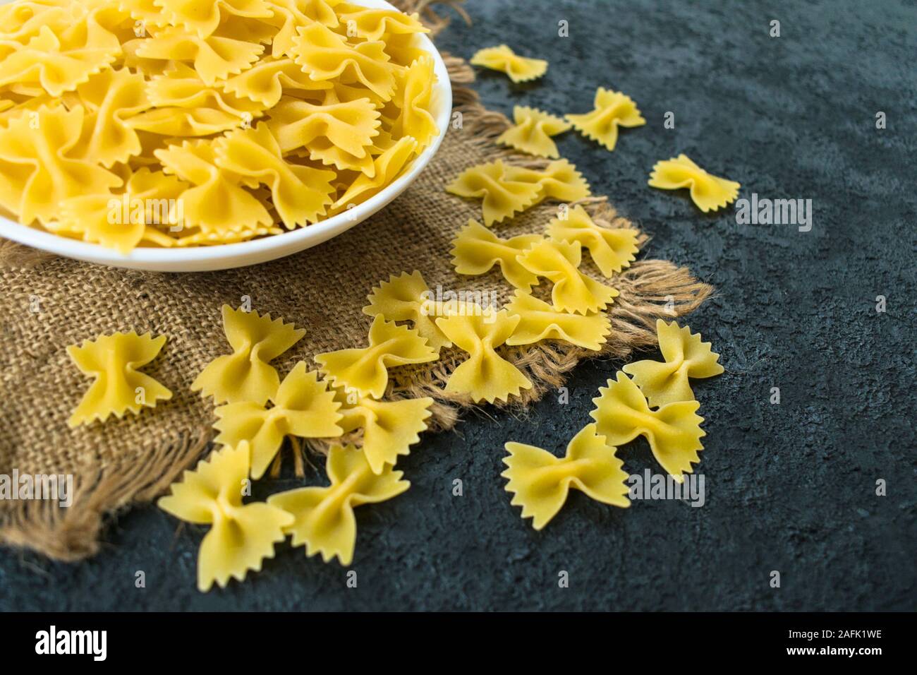 La pasta in forma di un arco in una piastra su uno sfondo nero. Foto Stock