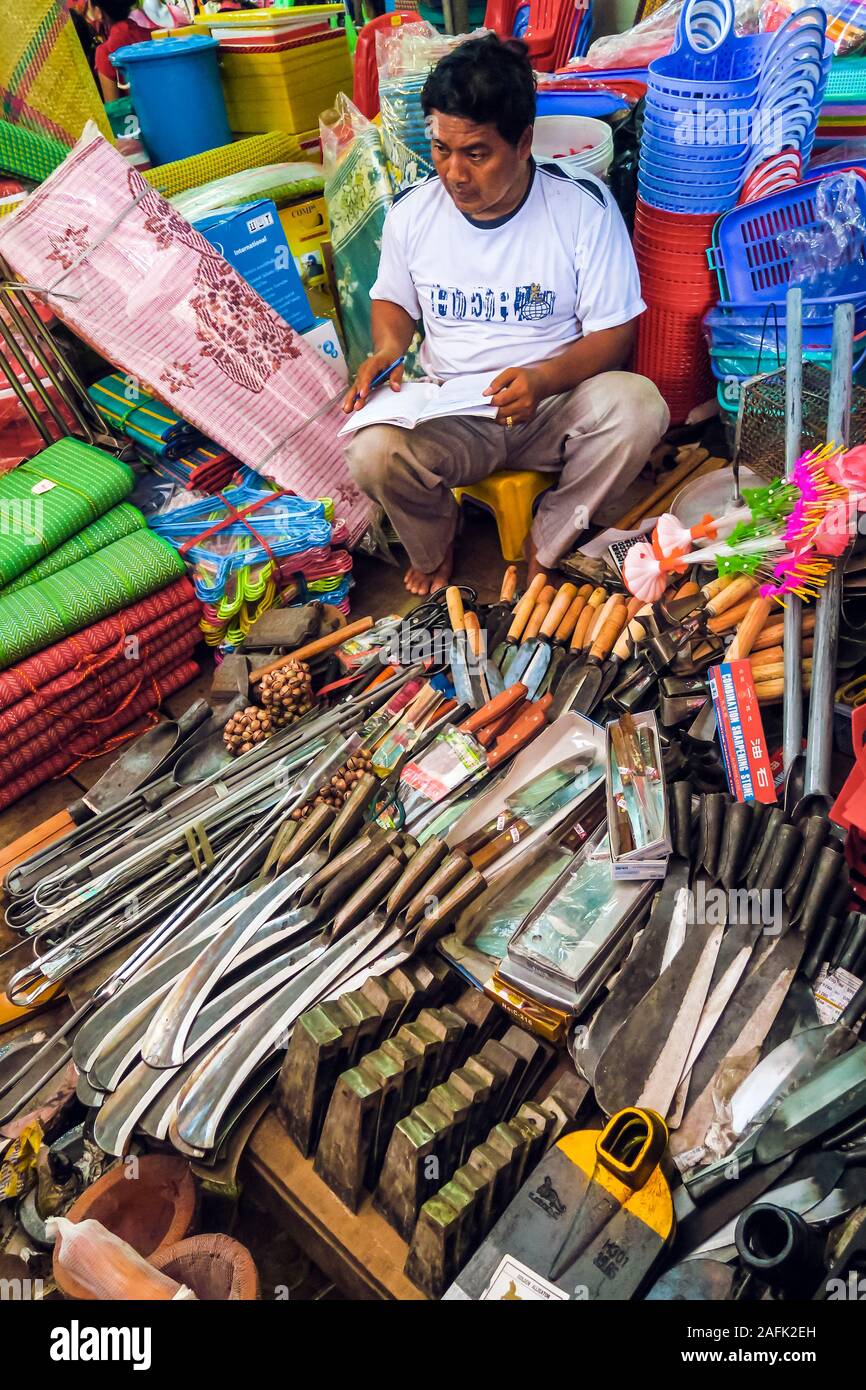 Uomo che vende lame per uso agricolo al mercato centrale in questa vecchia città coloniale francese porto, Kambot, Cambogia Foto Stock