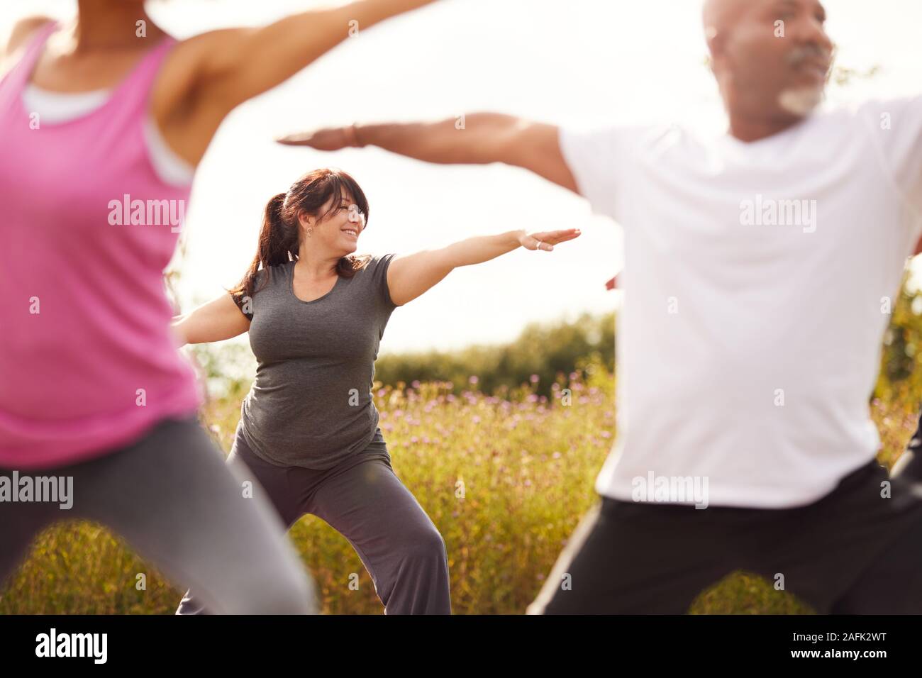Un gruppo di uomini e donne adulti in classe a Outdoor ritiro di yoga Foto Stock