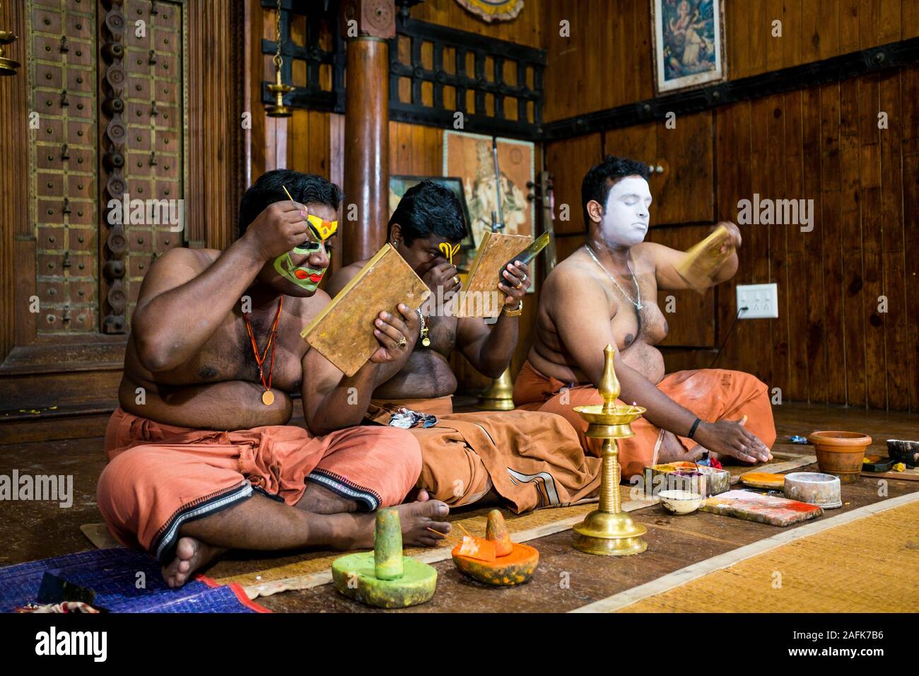 Kochi, India - 20 settembre 2019: kathakali attori preparare e applicare il make up prima di una performance di questa classica forma di teatro Foto Stock