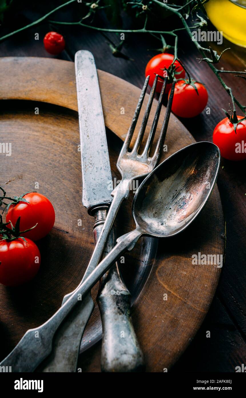 Vintage impostazione tabella con argento vecchio cucchiaio, coltello e forchetta in legno scuro piastra da sopra. Creative cena di ringraziamento ancora in vita. Ristorante silve Foto Stock
