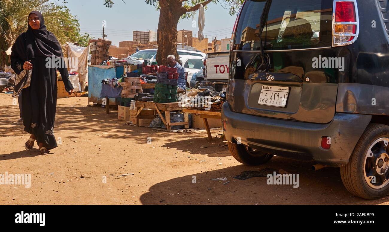 Il governo di Khartoum, Sudan, ca. Febbraio 8, 2019: mercato in stallo a Khartoum, con una macchina piccola e una donna nei tradizionali abiti neri Foto Stock