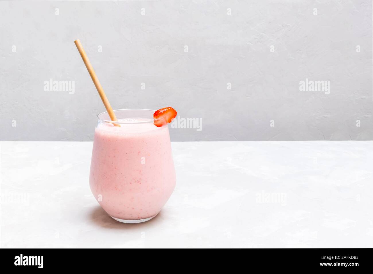 Tazza di bevanda indiana Strawberry Lassi su folle sullo sfondo di calcestruzzo Foto Stock