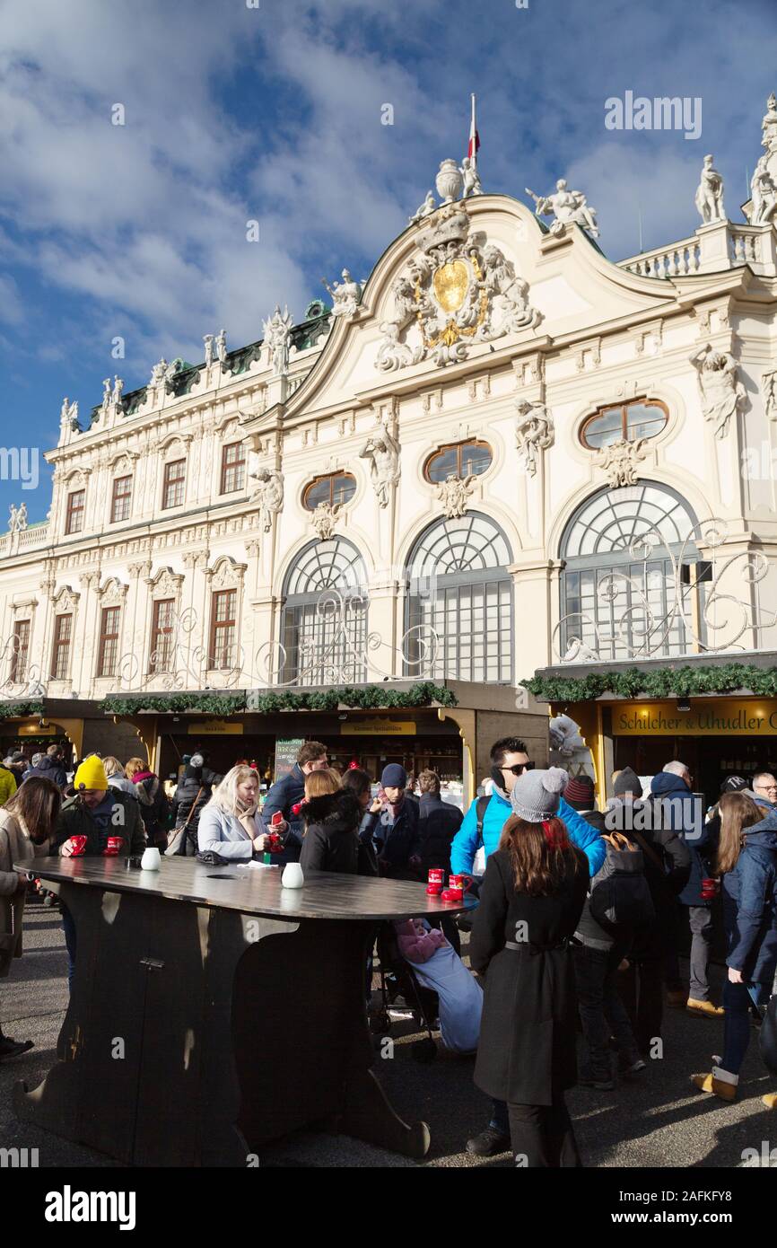 Gente che acquista e beve il gluhwein, il mercato di Natale del Belvedere, Vienna Austria Europa Foto Stock