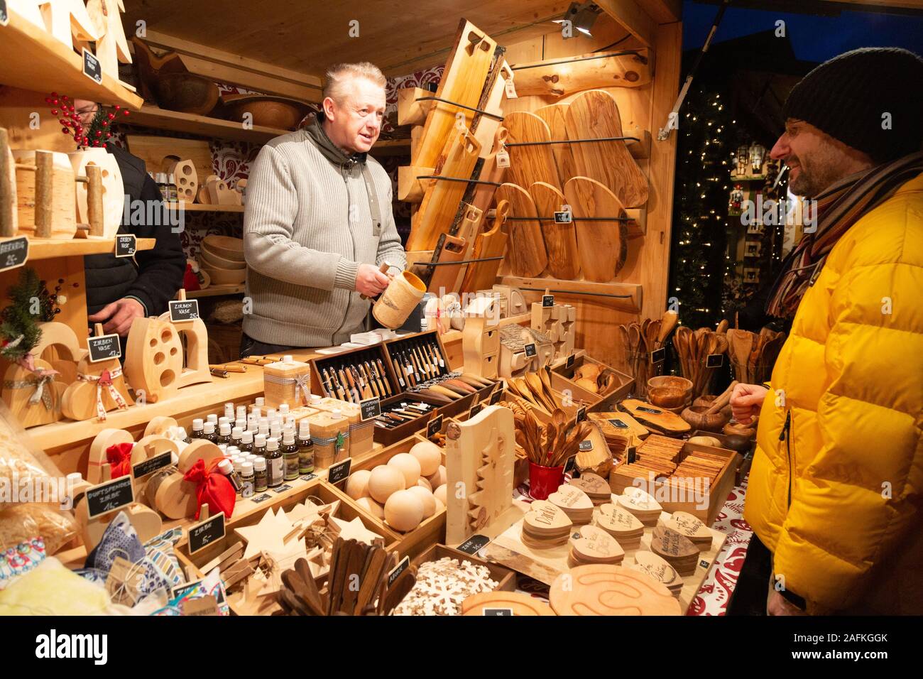 Mercatino di natale in Europa - un uomo che acquista oggetti artigianali in legno da una stalla, Palazzo Schonbrunn, mercato di Natale di Vienna, Vienna Austria Europa Foto Stock