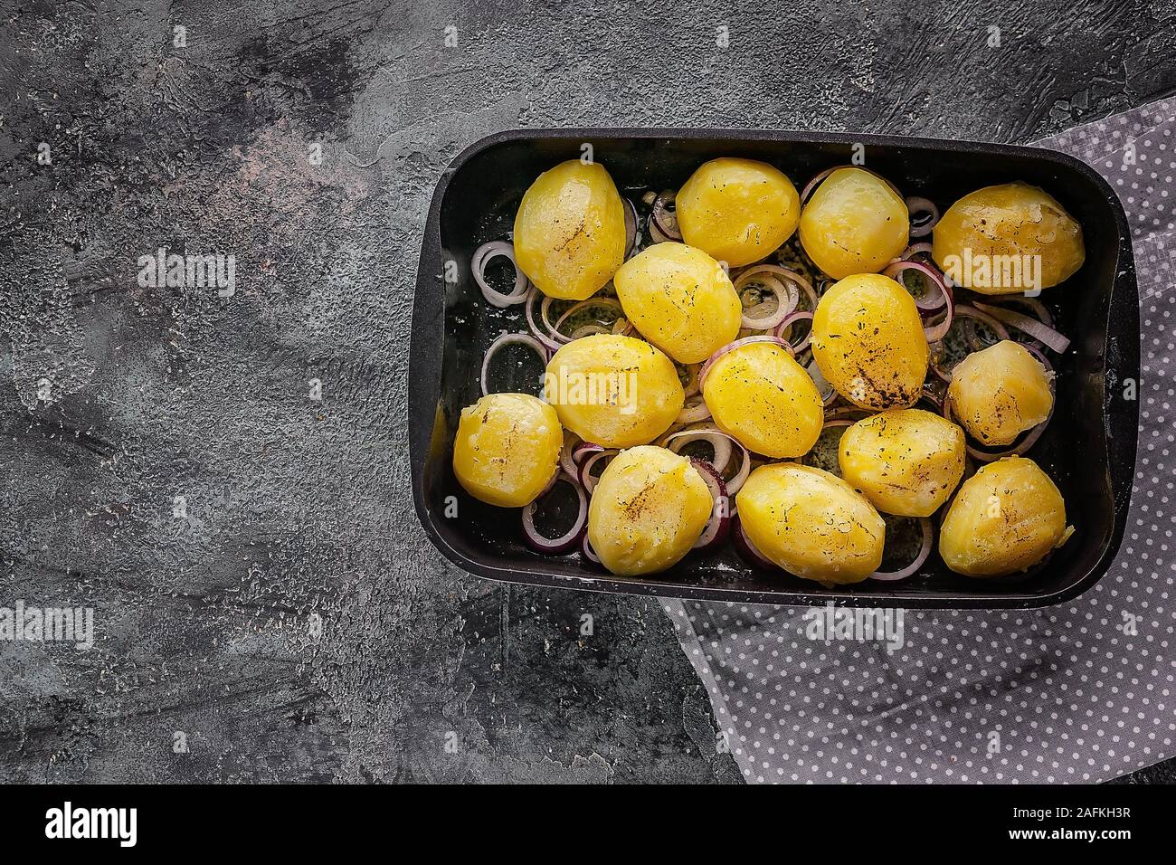 Vista dall'alto le patate al forno con le cipolle in una ghisa a stampo. Spazio di copia Foto Stock