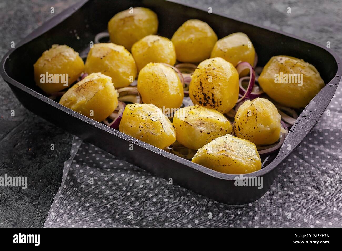 Close-up patate al forno con le cipolle in una ghisa a stampo. Foto Stock