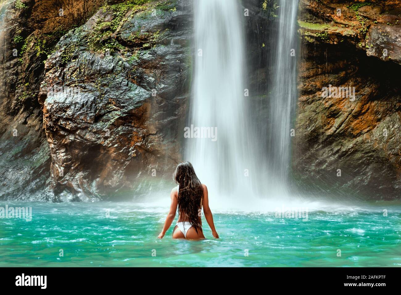 Turista femminile fotografare una cascata nella foresta Foto Stock