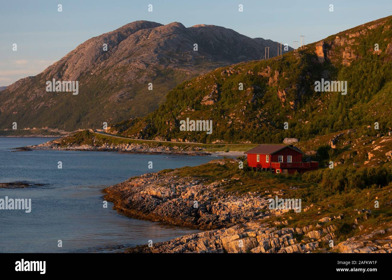 SOMMARØYA, Norvegia - Casa Rossa sulla costa rocciosa, il sole di mezzanotte, Troms, Norvegia settentrionale. Foto Stock