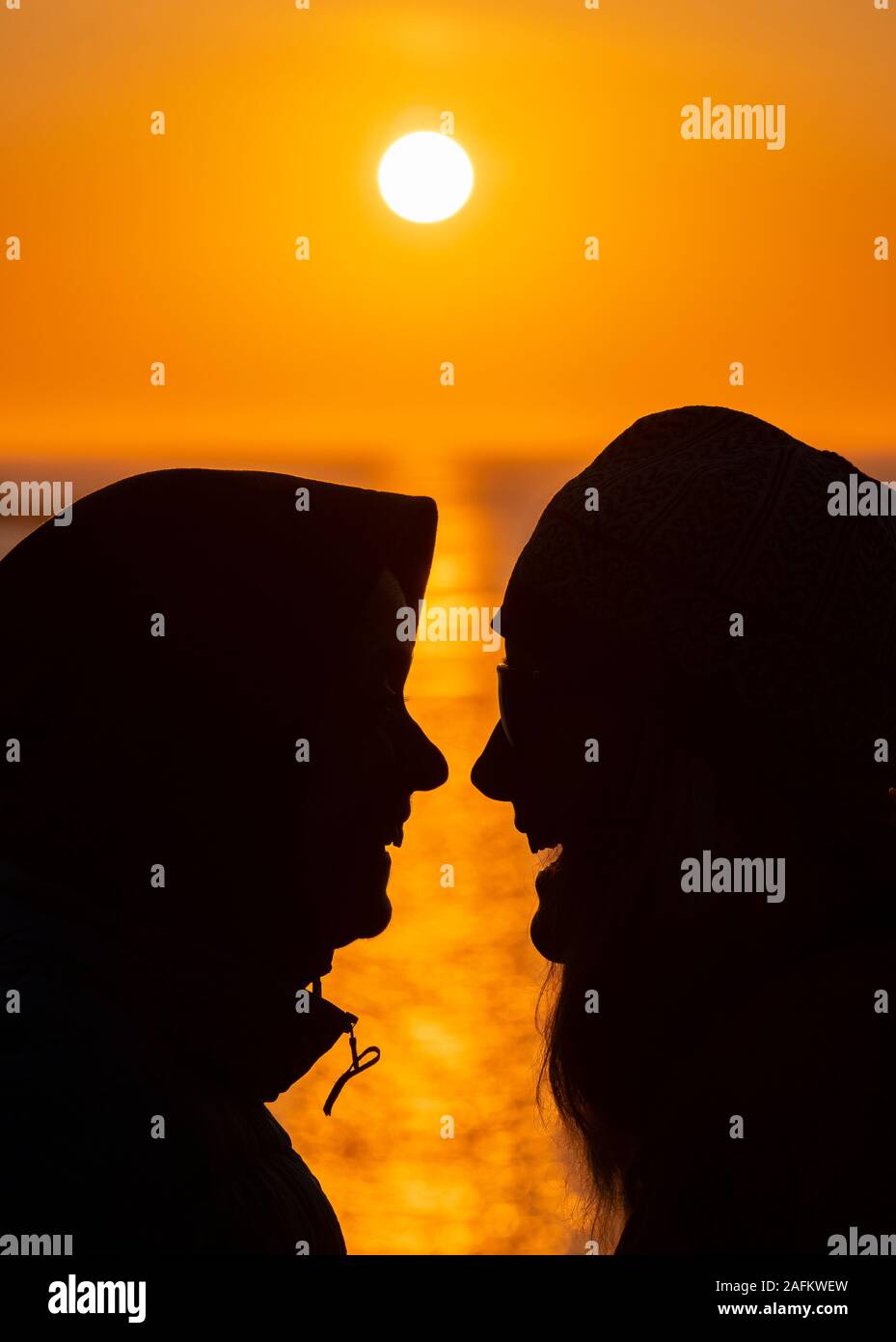 SOMMARØYA, Norvegia - Due donne a godersi il sole di mezzanotte, Troms, Norvegia settentrionale. Foto Stock
