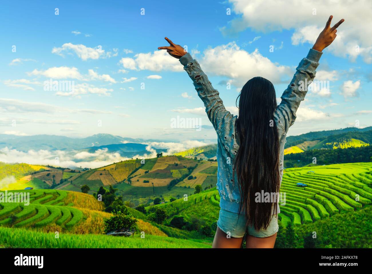 Donna che cammina nel campo di riso Bali Foto Stock