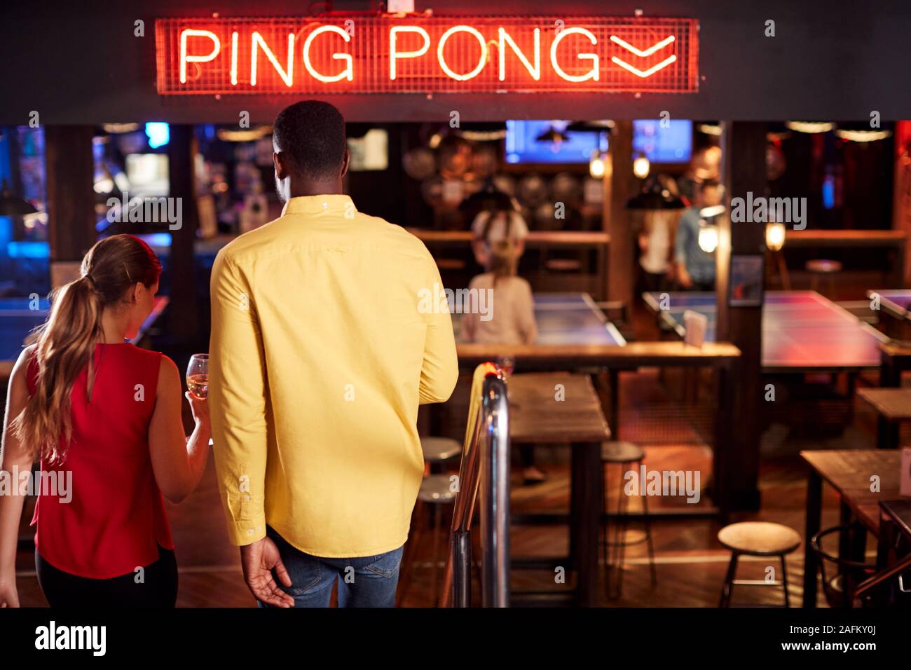 Vista posteriore del Dating giovane su scale come si incontrano per bevande e socializzare in bar Foto Stock