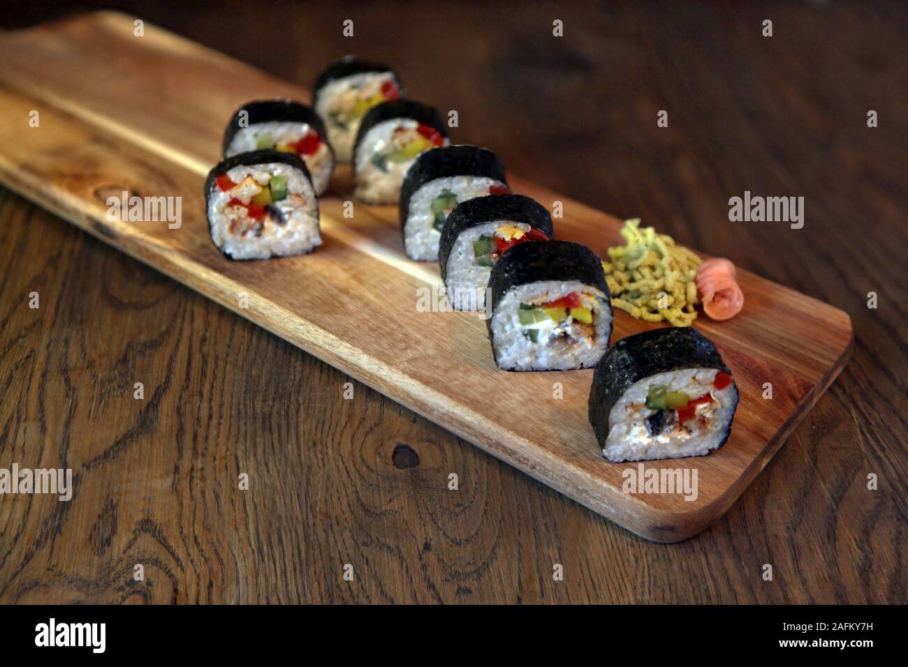 Hot roll impostare il sashimi il cibo giapponese su sfondo di legno con limone e bastoncini Foto Stock