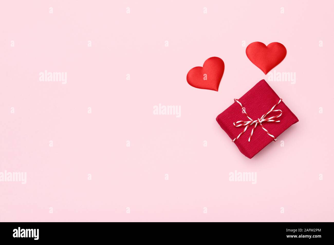 Il giorno di San Valentino cuori e confezione regalo su sfondo rosa. Foto Stock