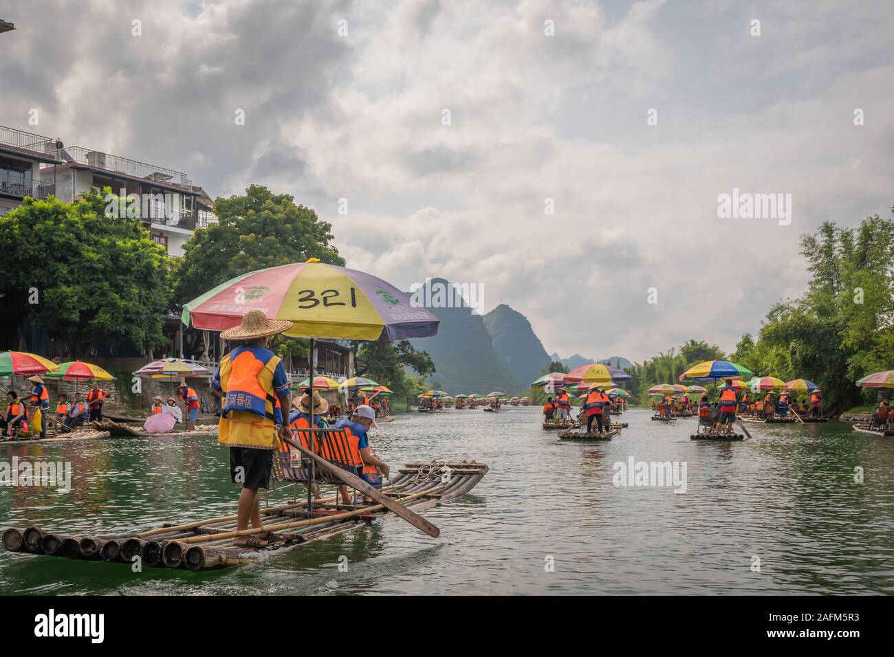 Yangshuo, Cina - Agosto 2019 : piccolo locale di trasporto turistico di passeggeri imbarcazioni di bambù di trasporto persone sul popolare escursione panoramica lungo il bellissimo paesaggio del Foto Stock