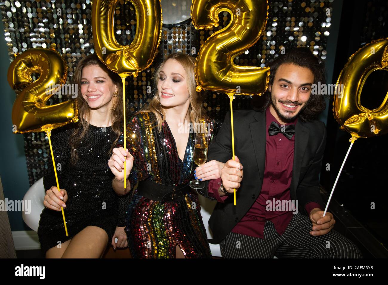 Felice giovani amici azienda golden numeri gonfiabile dell'anno successivo Foto Stock