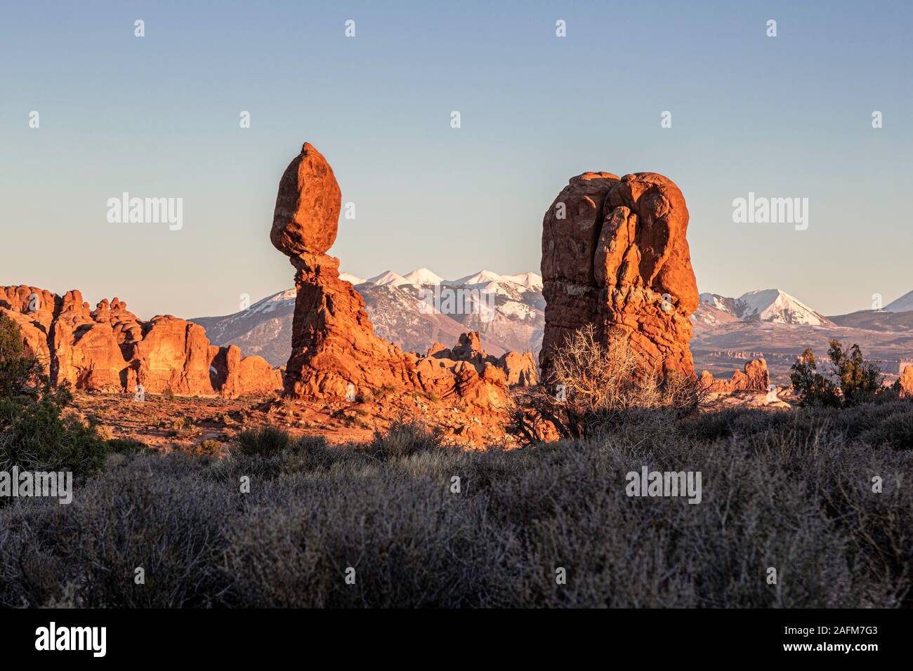 Roccia equilibrato, coperta di neve La Sal Mountains in background, Arches National Park, Moab, USA Utah Foto Stock