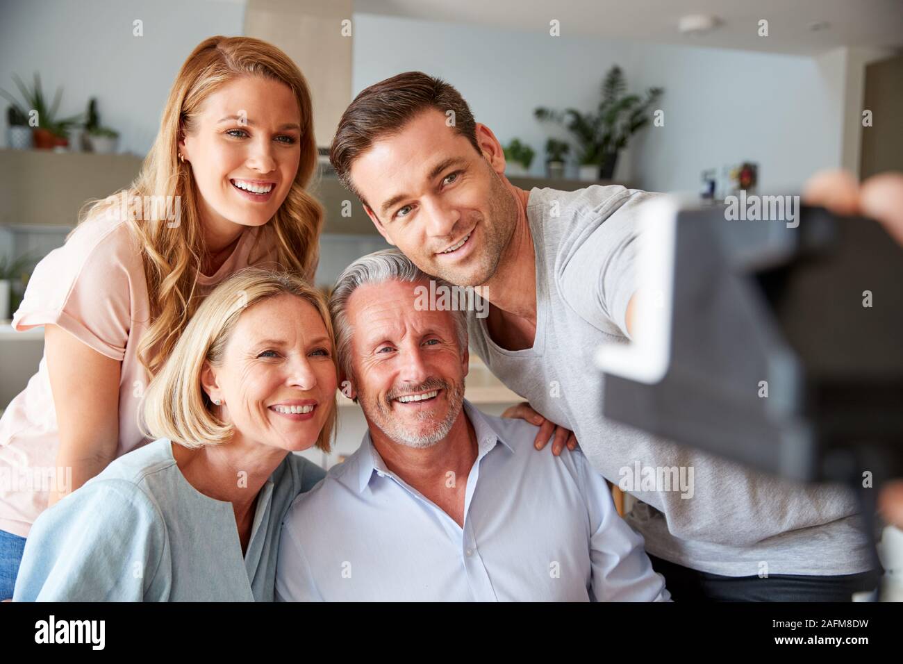 I genitori senior con adulto prole in posa per Selfie Su Vintage Pellicola Istante fotocamera Foto Stock