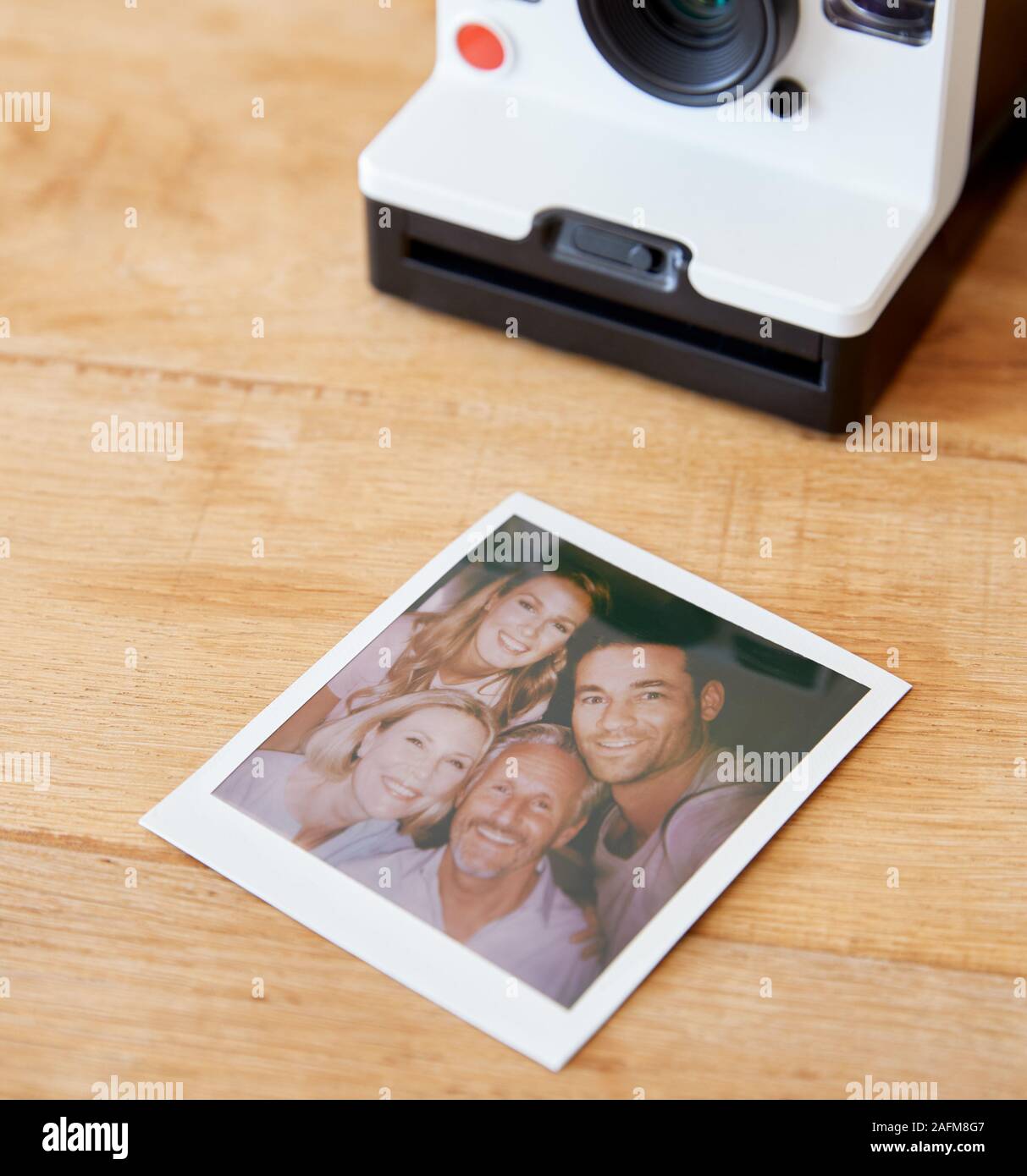 Vintage Pellicola Istante fotocamera con stampa di genitori Senior e adulto prole in posa per Selfie Foto Stock