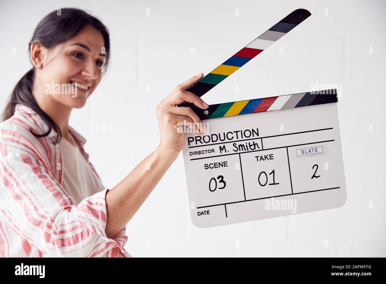 Videografo femmina azienda battaglio Scheda Video sul film di produzione in studio bianco Foto Stock