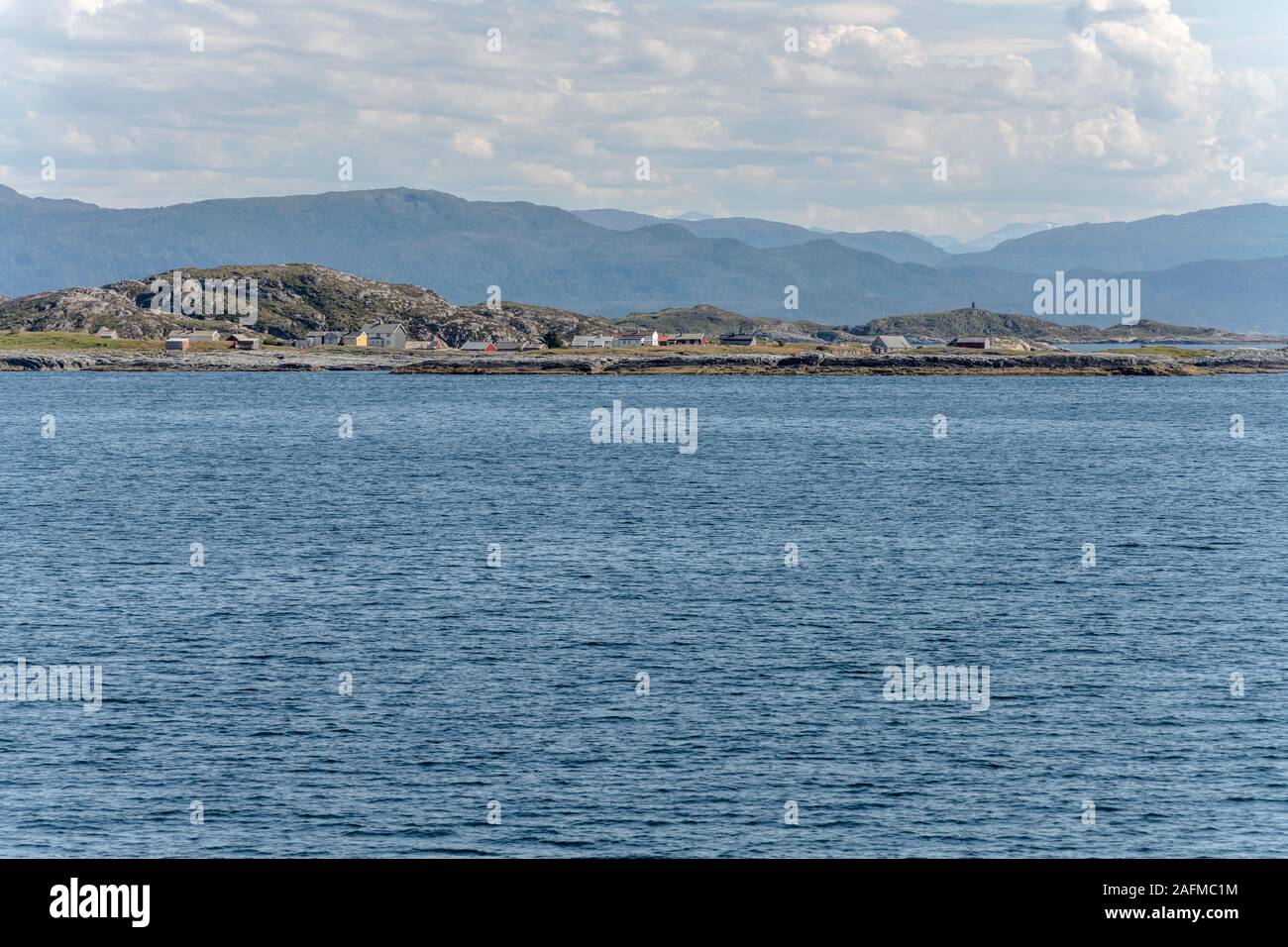 Paesaggio del fiordo con distanziati case sull isola piatta riva, girato sotto la luminosa luce estiva a Skardsoya, Norvegia Foto Stock