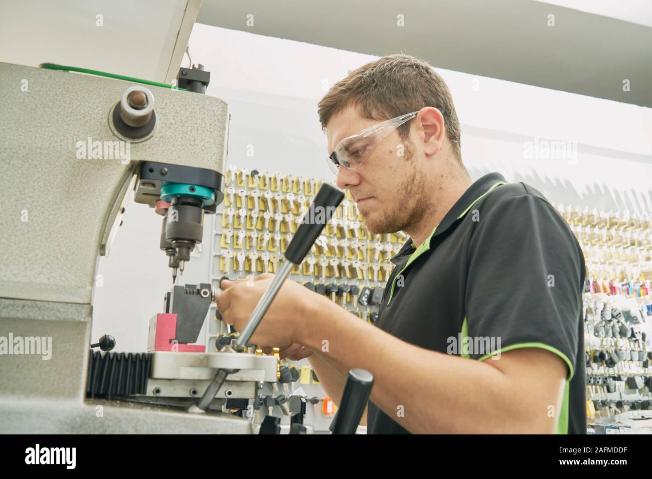 Fabbro lavora su il duplicato di una chiave nella macchina duplicatrice Foto Stock