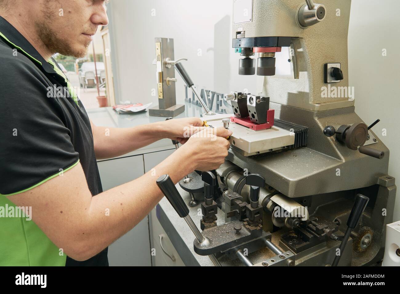 Fabbro lavora su il duplicato di una chiave nella macchina duplicatrice Foto Stock