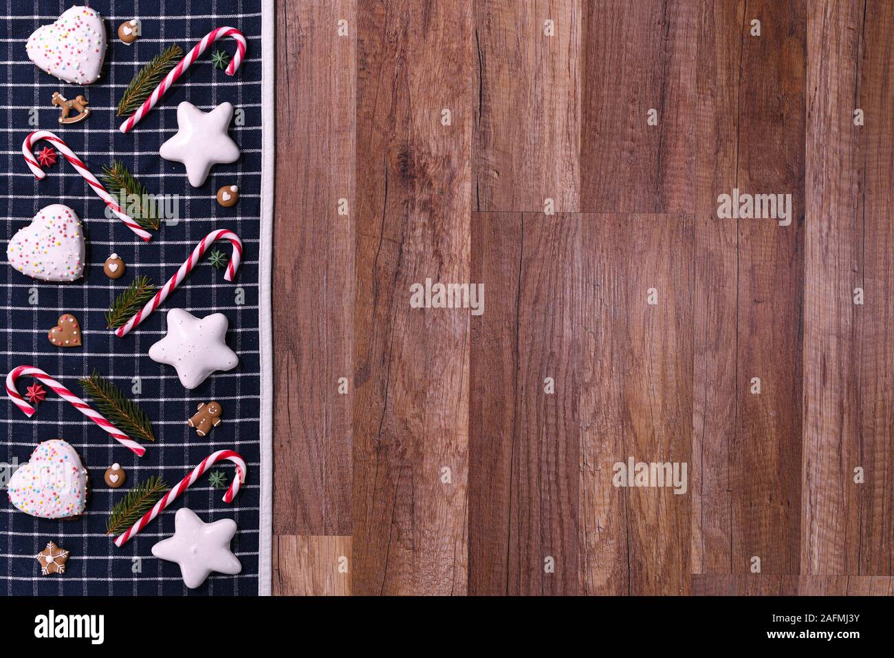 Carta di Natale con abete di Natale, spezie cannella bastoncini, anice star, arance e pane zenzero su sfondo rustico in legno. Foto Stock