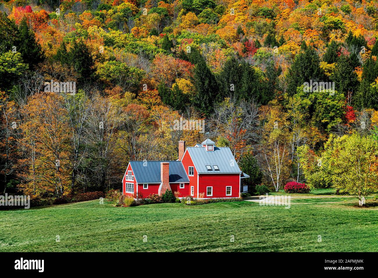 Affascinante casa rossa fiancheggiata da fogliame di autunno, Bridgewater, Vermont, USA. Foto Stock