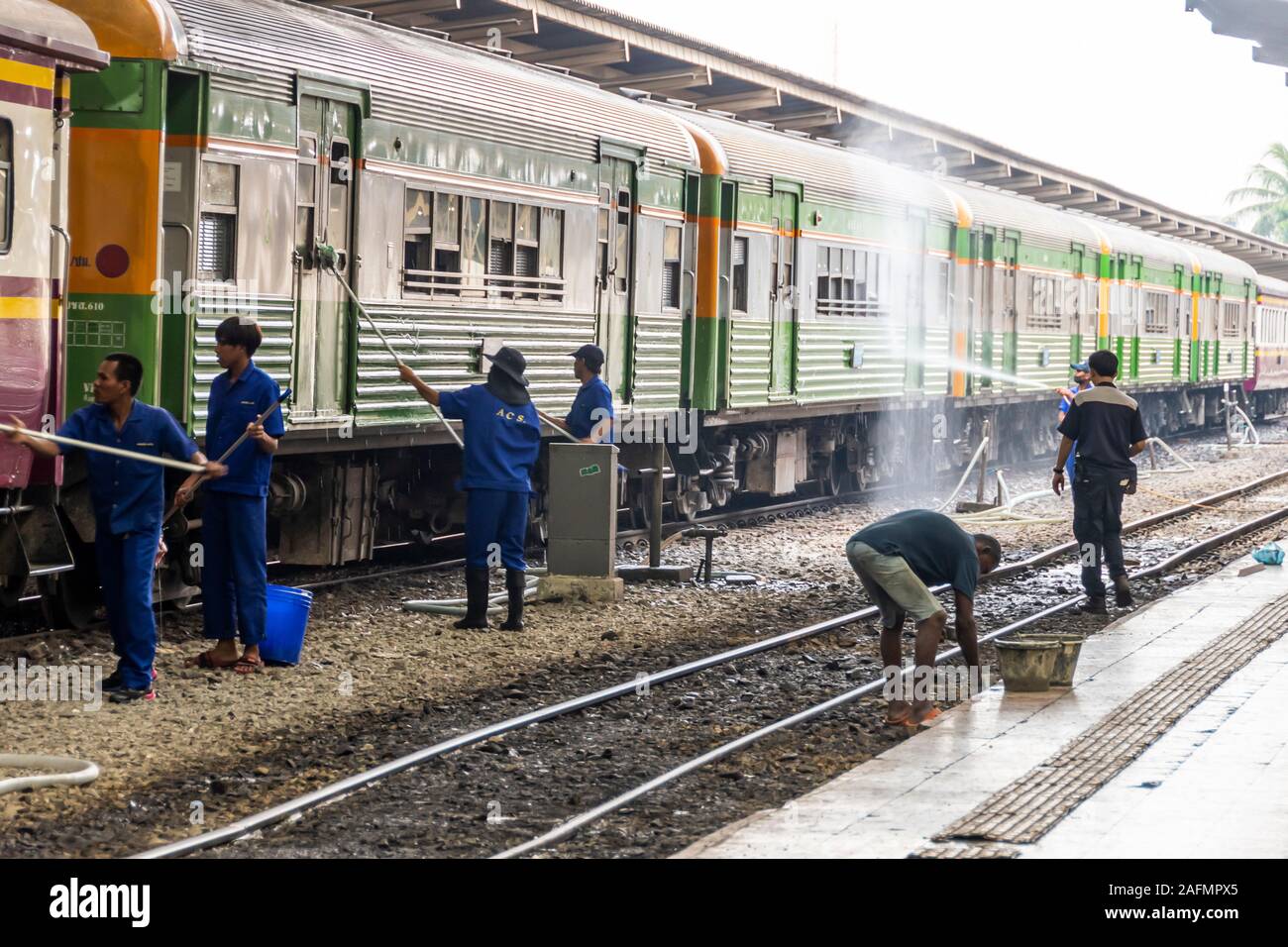 Pulizia dei lavoratori carrozze ferroviarie alla stazione di Bangkok, Thailandia Foto Stock
