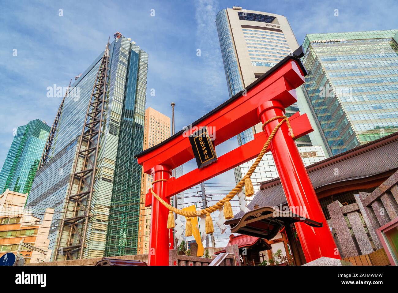 Tradizione e modernità in Giappone. Vista di Shimbashi-Shiodome moderni grattacieli dietro la porta rossa di Hibiya Santuario nel centro cittadino Foto Stock