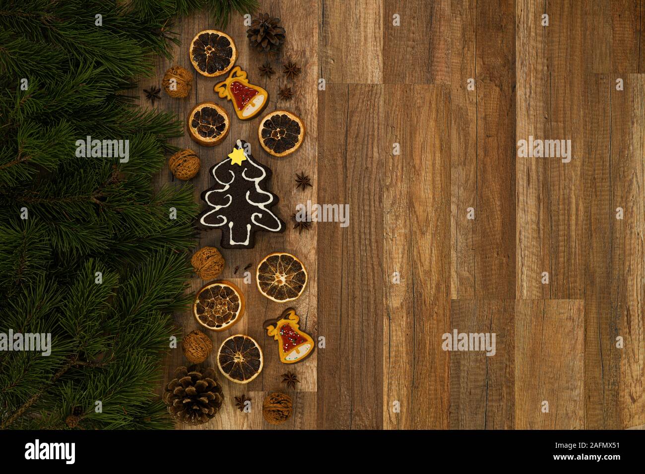 Carta di Natale con abete di Natale e pane allo zenzero su sfondo rustico in legno. Foto Stock