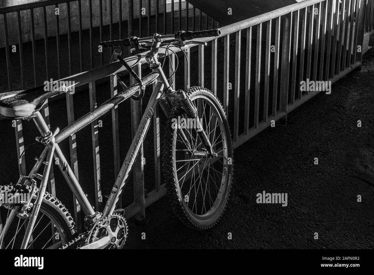Un bycycle lasciato incustodito nel garage parcheggio con luce e ombre Foto Stock
