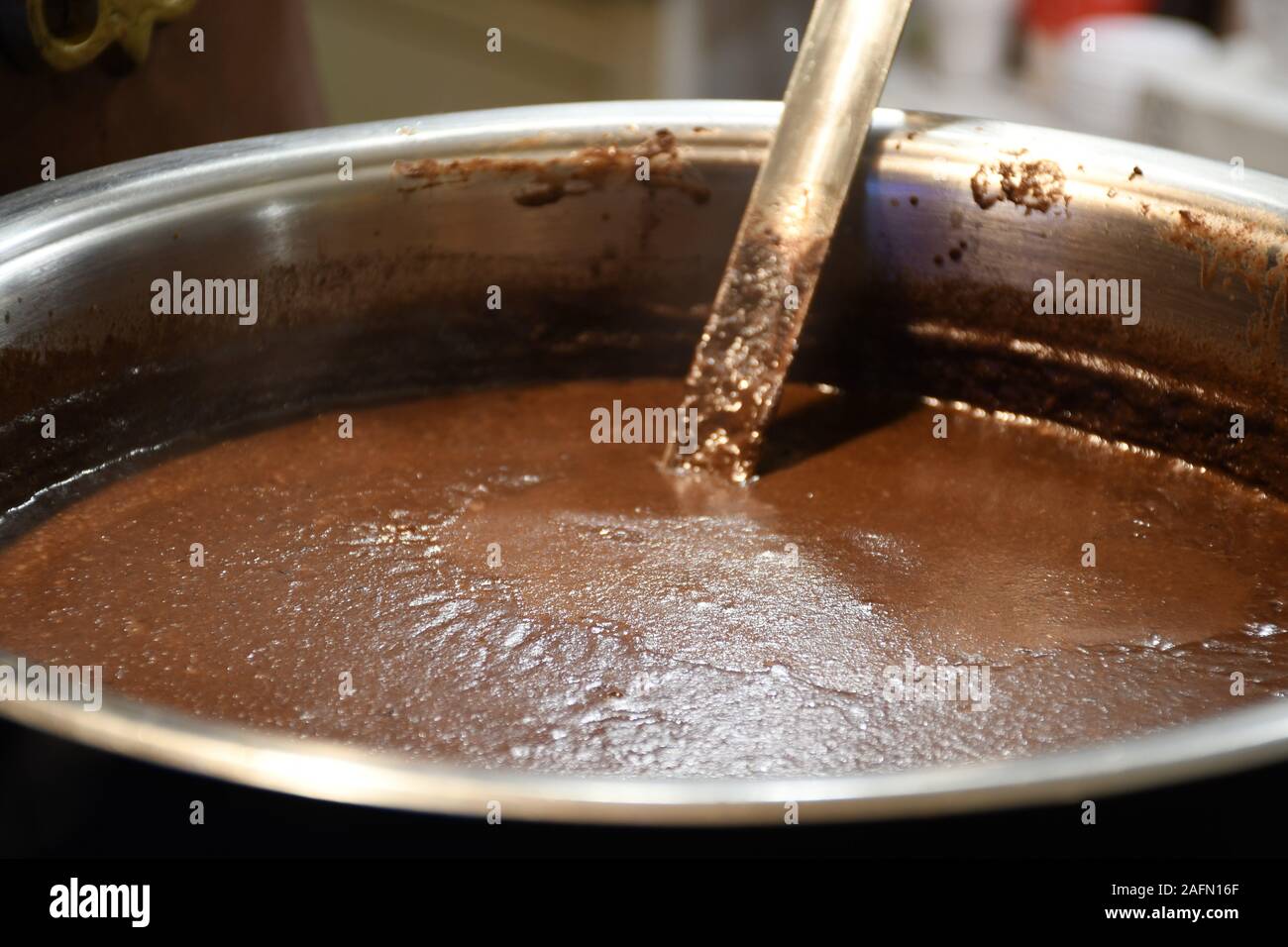 Hot cioccolato fondente in in una grande pentola di rame in un mercato di Natale, pronto a mangiare cibo di strada in inverno Foto Stock