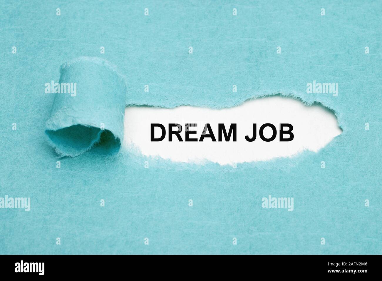 Il testo stampato job di sogno che appaiono dietro strappato carta blu. Concetto di trovare il perfetto sogno di posti di lavoro. Foto Stock