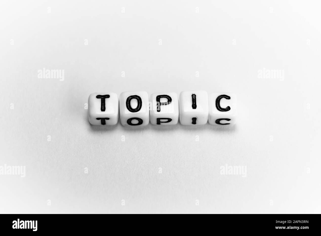 Cubi di bianco con word argomento su carta bianca di sfondo e ombre scure Foto Stock